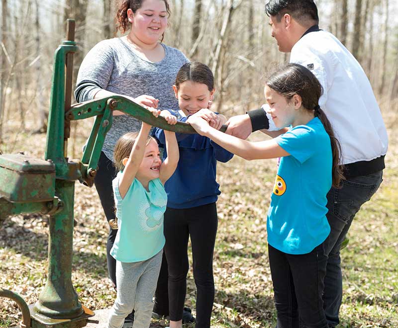 Family using a water pump outdoors