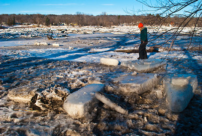 Person walking on ice breaking up from a river