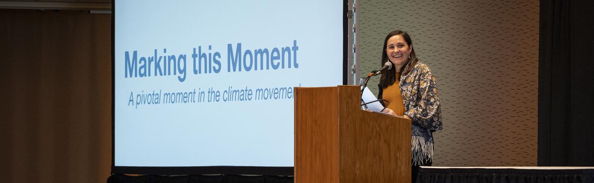 MCAP director Heidi Roop stands at a podium at a conference