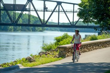 a woman biking along a river